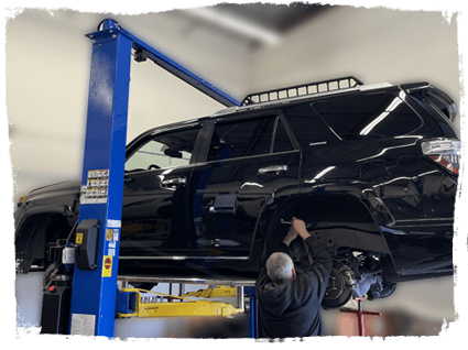 A truck on a lift inside Outlander Motorsports of Martinez, CA, getting service for general maintenance and autor repairs