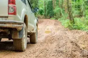 Do You Really Need a 4WD to Go Off-Roading? | Outlander Motorsports in Martinez, CA. Image of a 4WD truck traversing the countryside’s muddy road.