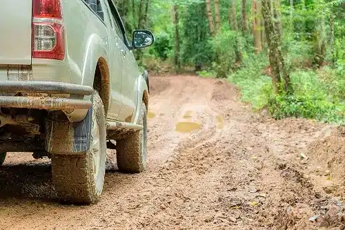 Do You Really Need a 4WD to Go Off-Roading? | Outlander Motorsports in Martinez, CA. Image of a 4WD truck traversing the countryside’s muddy road.