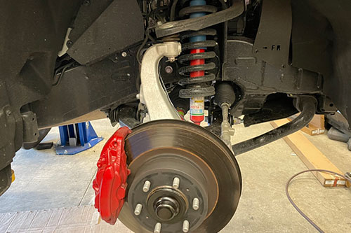 Holiday Travel Tips: Brake Inspection in Martinez, CA at Outlander Motorsports.Closeup image of brakes on vehicle in shop bay getting ready to be replaced.