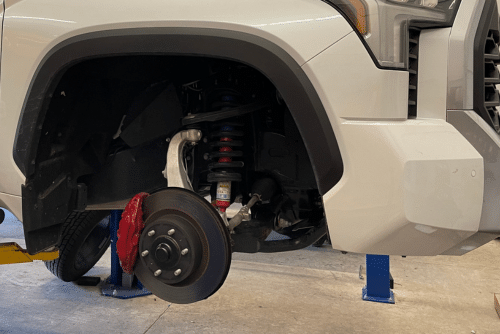 Brake repair in Martinez, CA by Outlander Motorsports. Image of a lifted Toyota Tundra with a close-up of the brake rotor and disc undergoing repair.