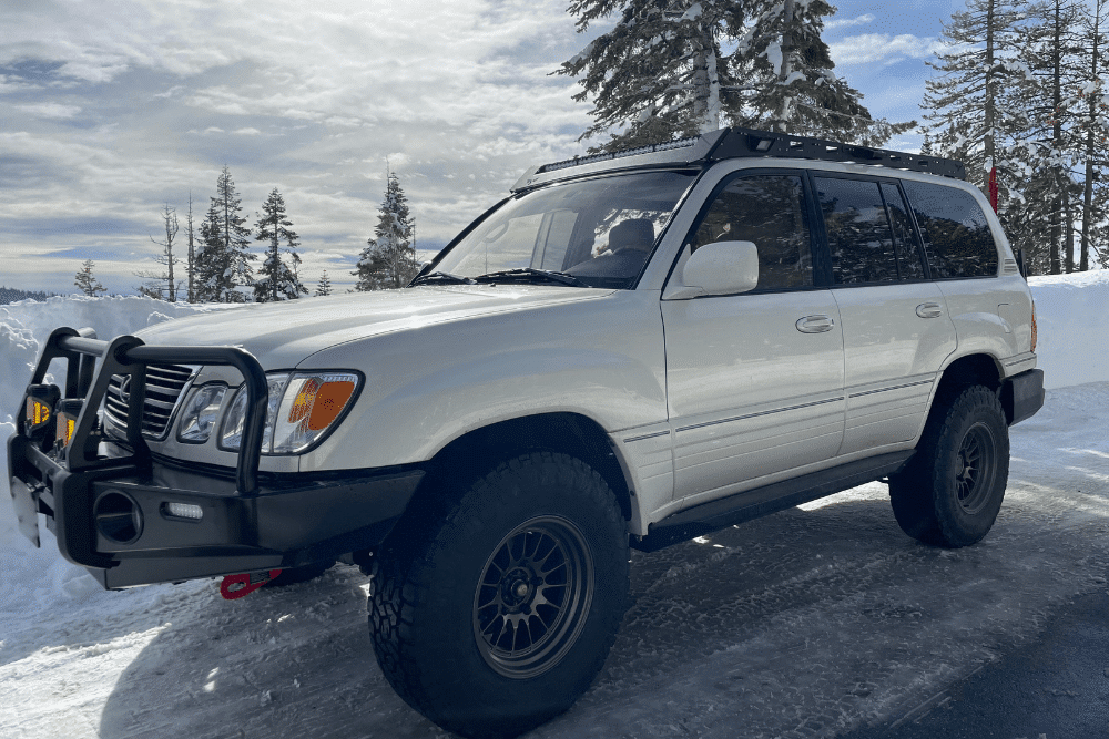 Winter Off-Road Modifications, Off-Road and Overlanding Customization in Martinez, CA at Outlander Motorsports. Image of a white SUV equipped with off-road upgrades, including a front bull bar and roof rack.