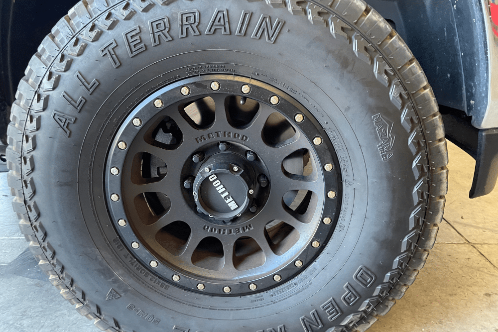 tires, Off Road Specialist in Martinez, CA at Outlander Motorsport. All-terrain tire with a rugged Method Race Wheel rim, showing aggressive tread design ideal for off-road driving.